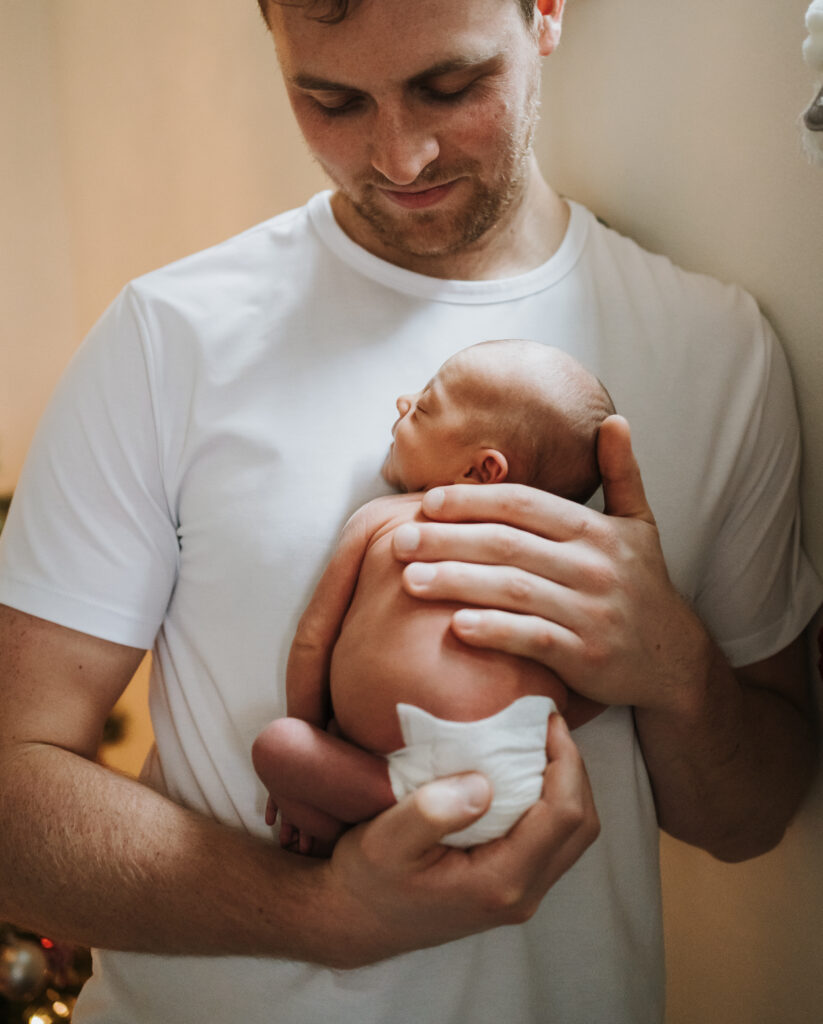 New Dad holding newborn baby Portland Birth Photographer